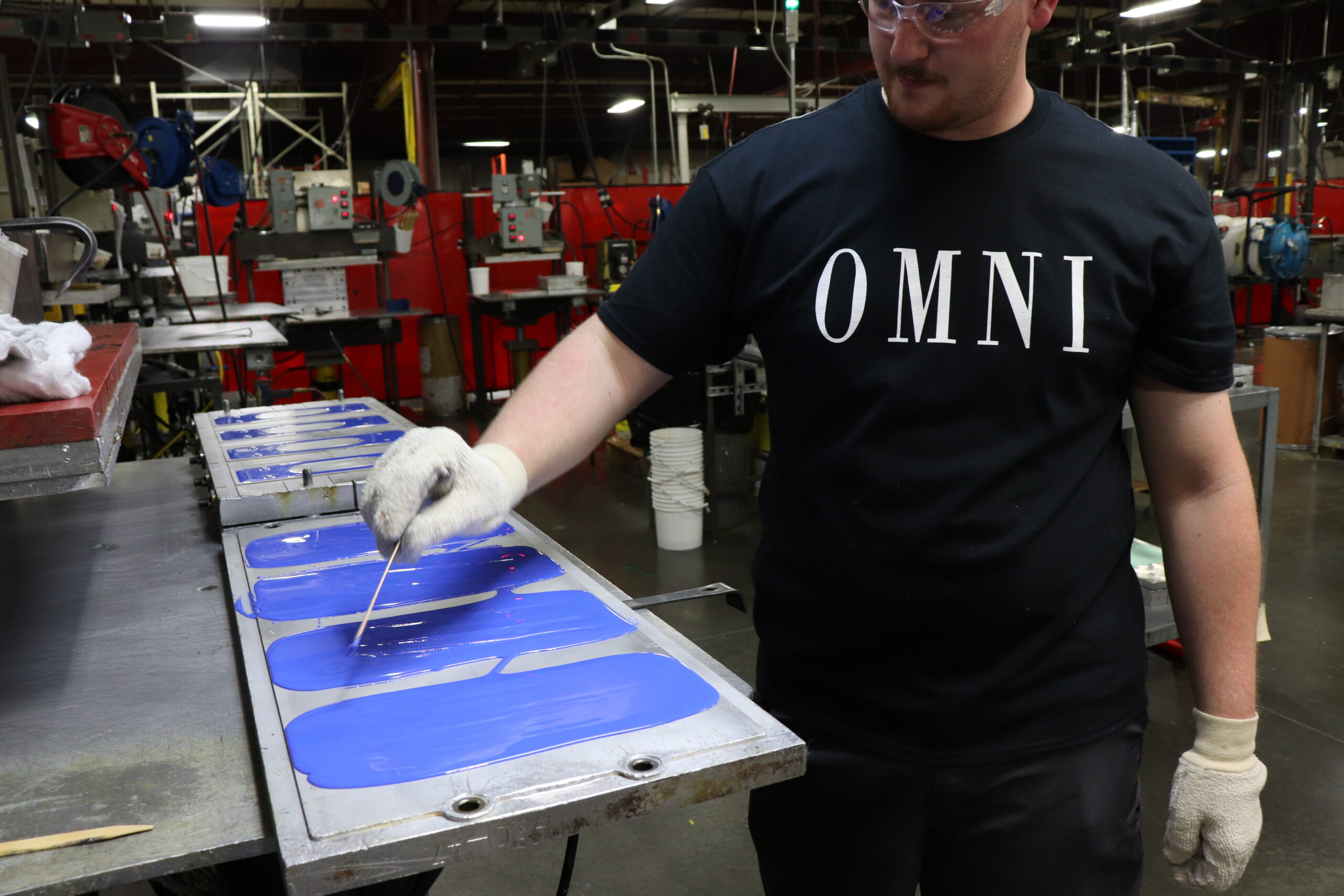 OMNI team member stirring plastic in mold